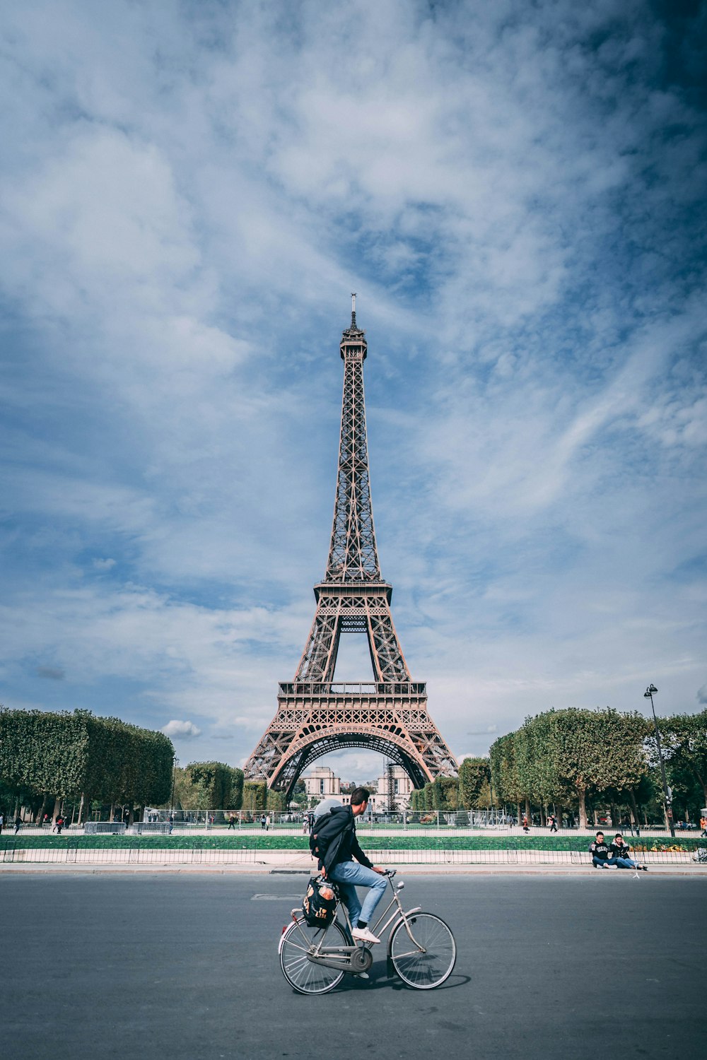 man riding on bicycle near eiffel tower during daytime
