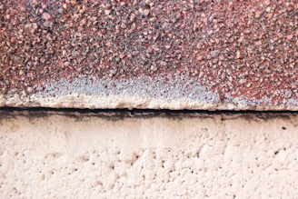 Close-up of a deep ripe crimson plaster finish highlighting the texture of the island pebble surface.