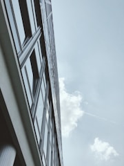A high-resolution aerial shot of a tall city building captured by a drone on a clear day.