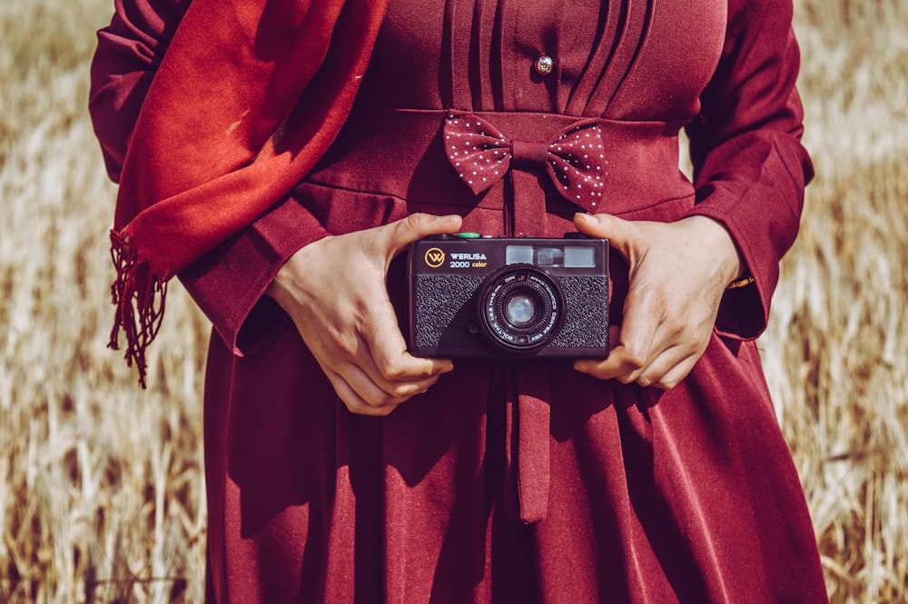 woman holds camera below her hips