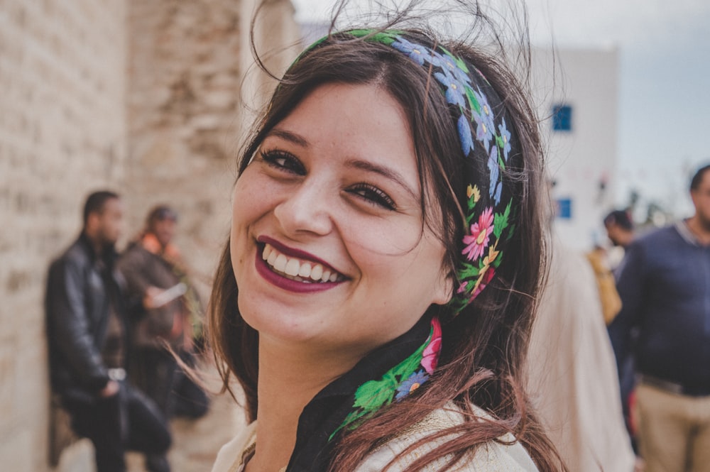 woman wears red lipstick and floral headband