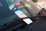 Image of a car with a visible traffic fine notice on the windshield.