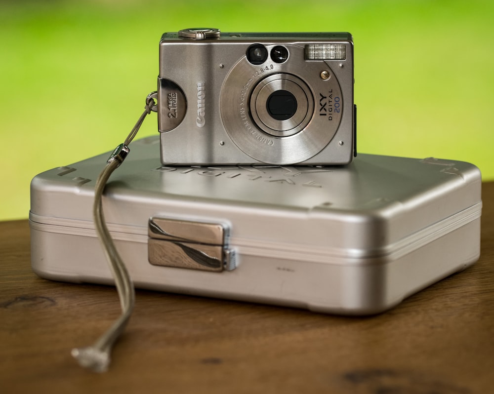 silver Canon compact camera on gray hardside case
