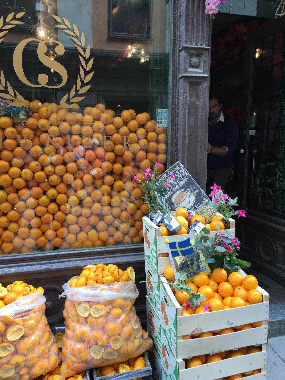 Una exhibición de naranjas frente a una tienda