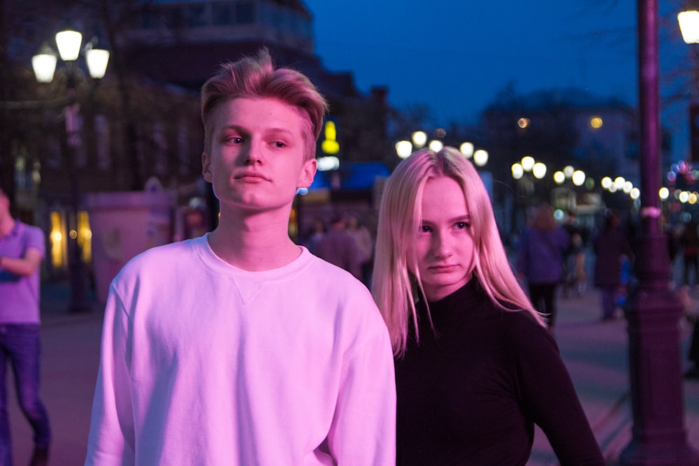 man and woman standing near people