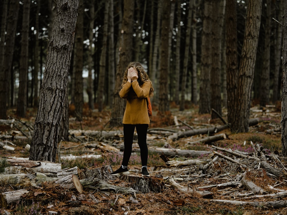 woman covering eyes with both hands at daytime