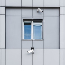 two security cameras on the side of a building
