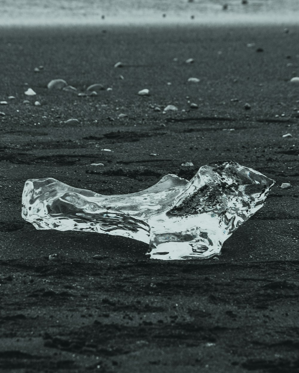 clear ice on black sand at daytime
