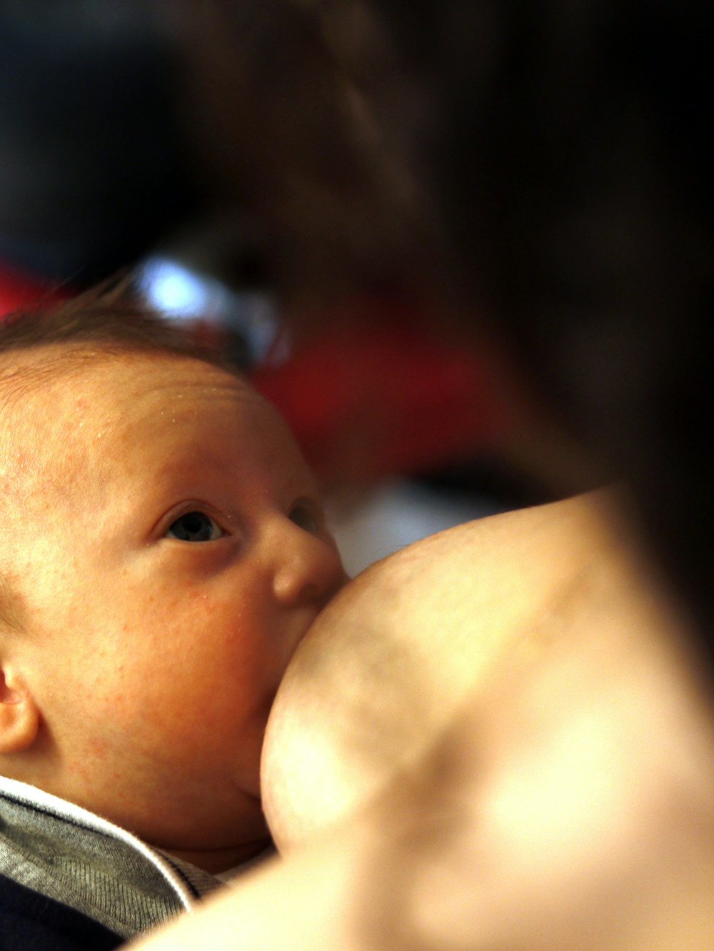 closeup photo of baby breastfeeding