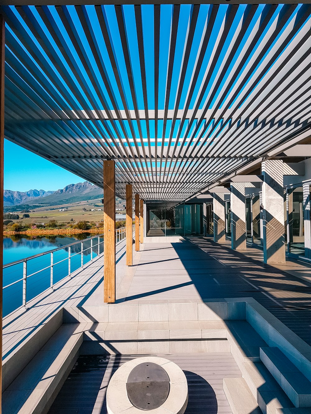 a walkway with a bench under a metal roof