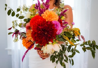 a woman holding a bouquet of flowers in her hands