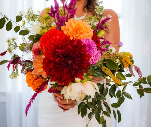 a woman holding a bouquet of flowers in her hands