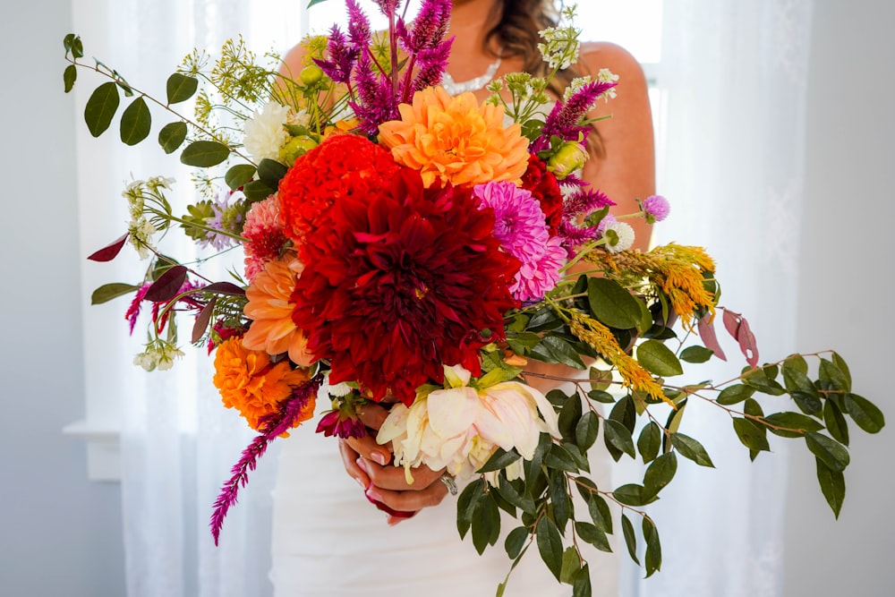 a woman holding a bouquet of flowers in her hands