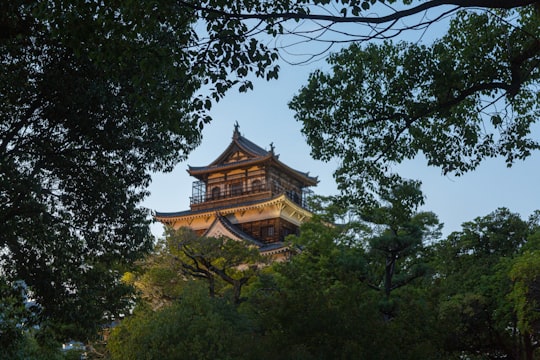 green trees near brown building during daytime in Hiroshima Castle Japan