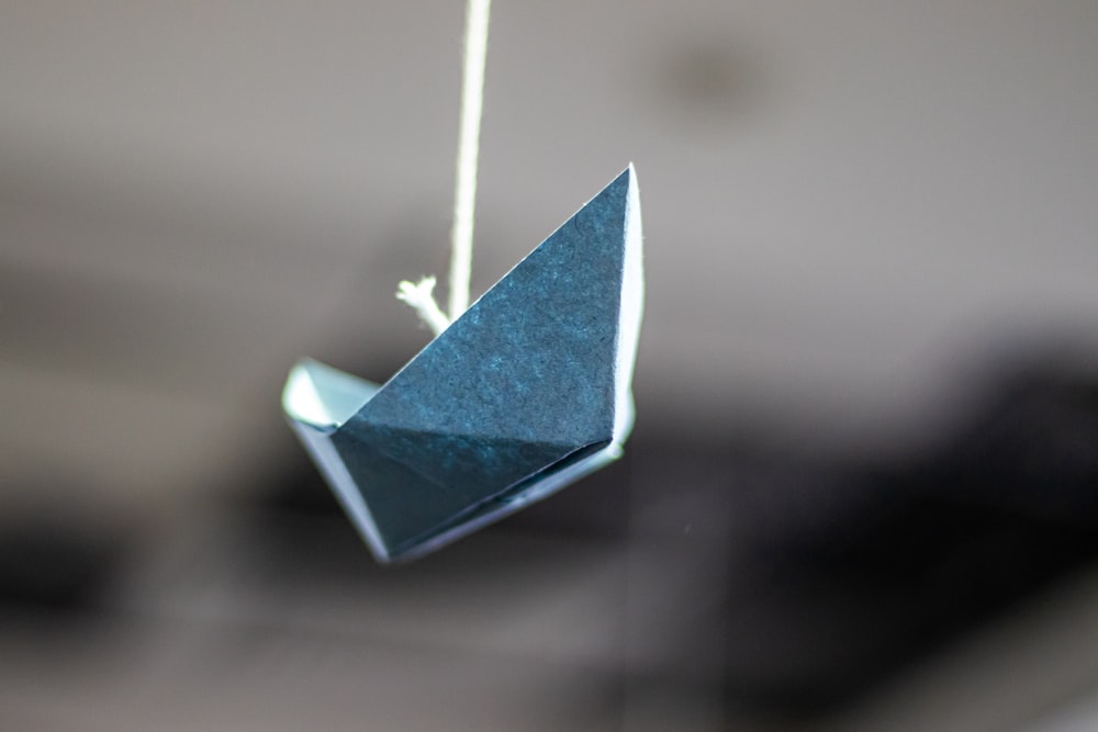 macro photography of blue paper boat