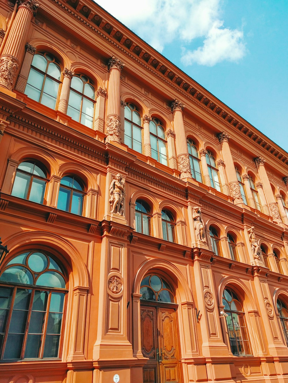 brown historic building under blue and white skies during daytime