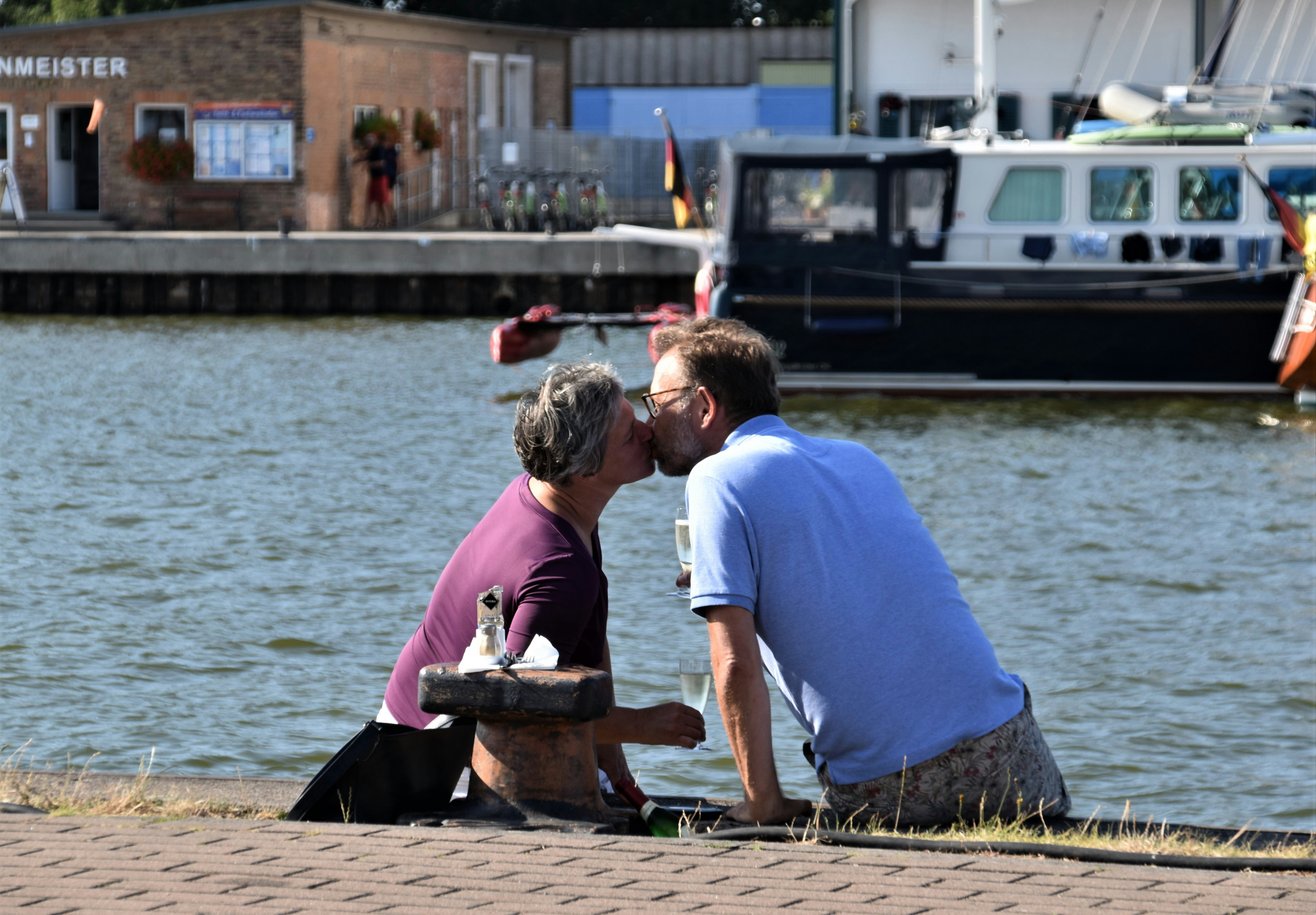 man kisses woman near shore