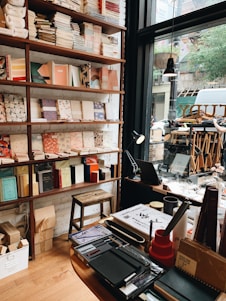 Cozy stationery shop interior with colorful notebooks and gift items neatly displayed on wooden shelves.
