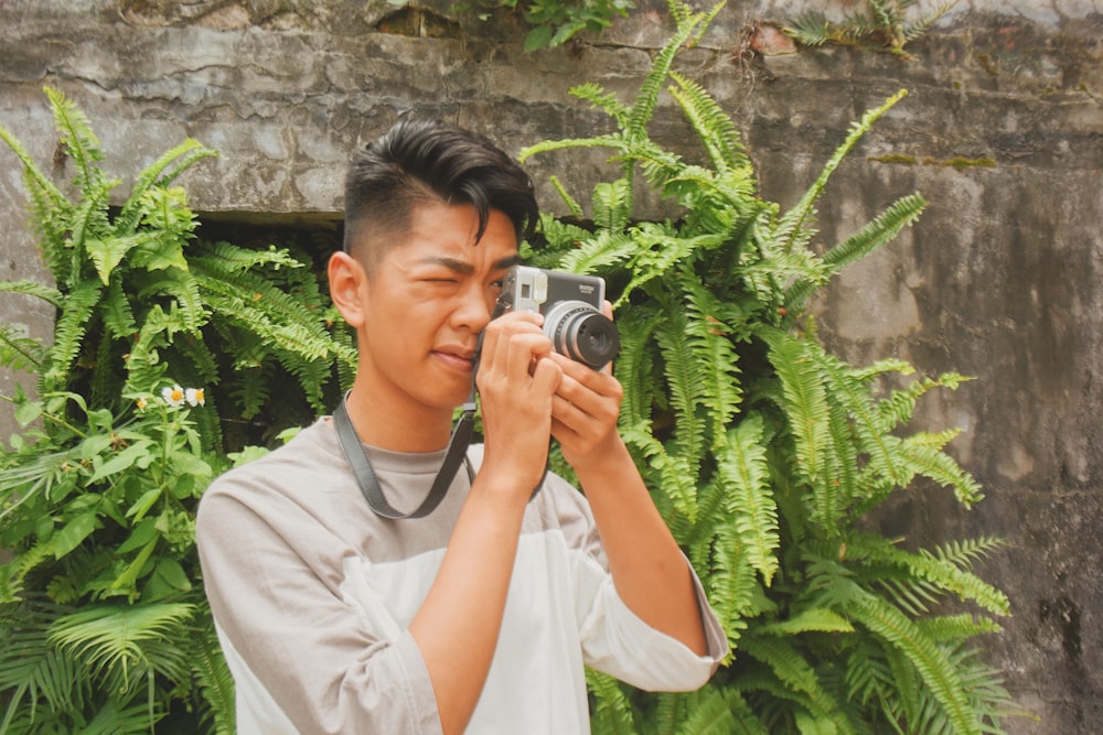 男性が植物の近くで写真を撮る