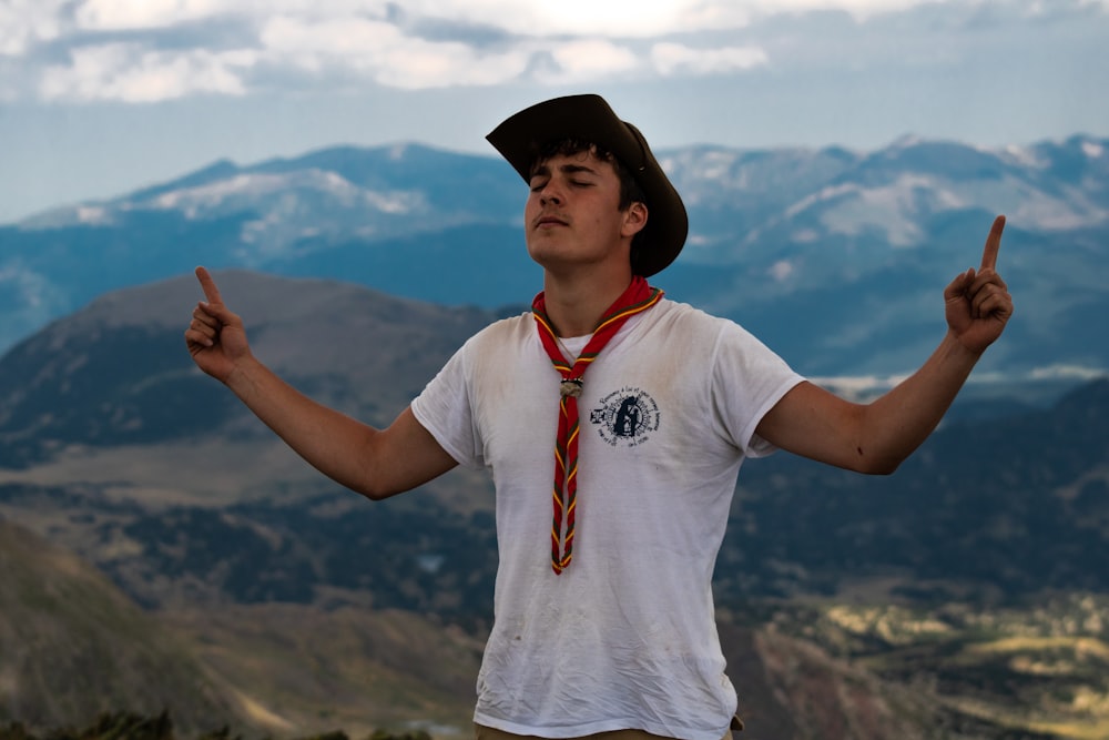 man in white t-shirt wearing scarf and black hat