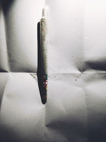 A colorful lineup of magic roll mushroom preroll packages with bold, liquid swirl designs in blue, green, purple, red, and gold.