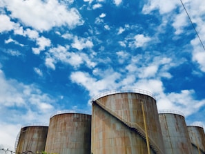 Close-up of a large metallic storage tank with shiny welded seams under bright sunlight