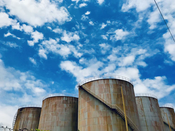 A professional team inspecting a large diesel fuel storage tank under a clear sky.