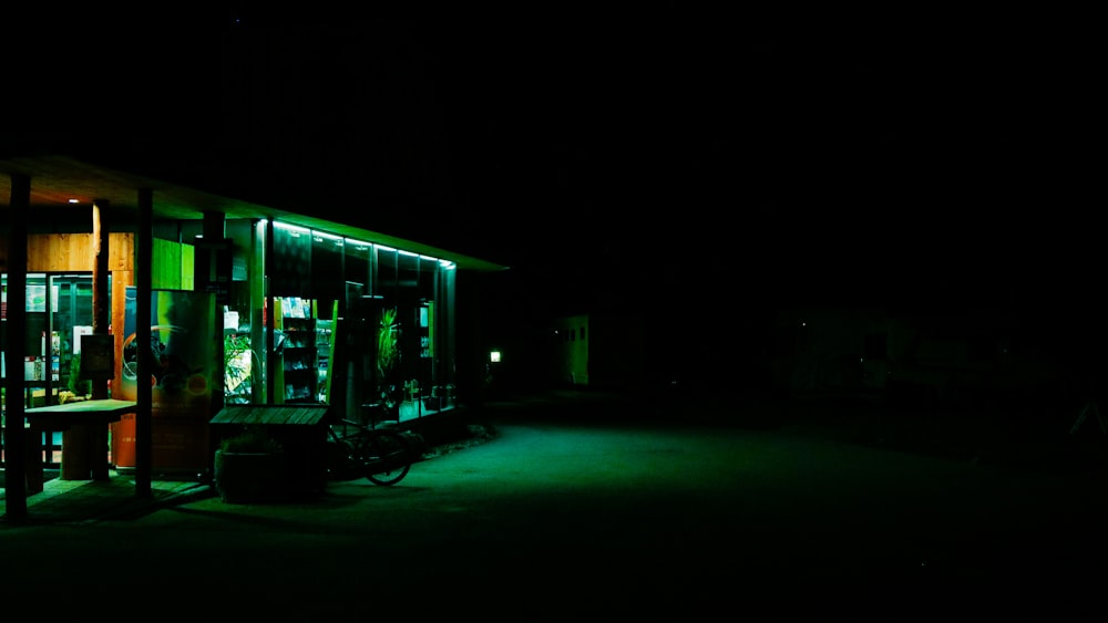 a lit up building at night with a bicycle parked in front of it