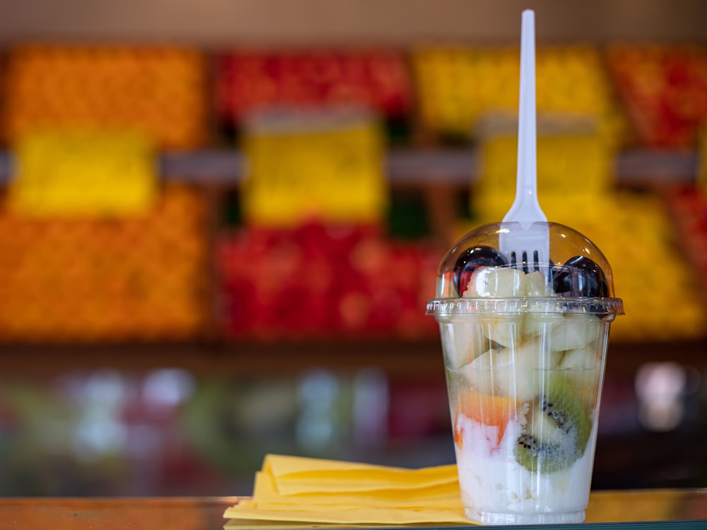 Fotografía de enfoque selectivo de tenedor en la parte superior de un vaso desechable