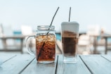 a glass of iced tea next to a jar of iced tea