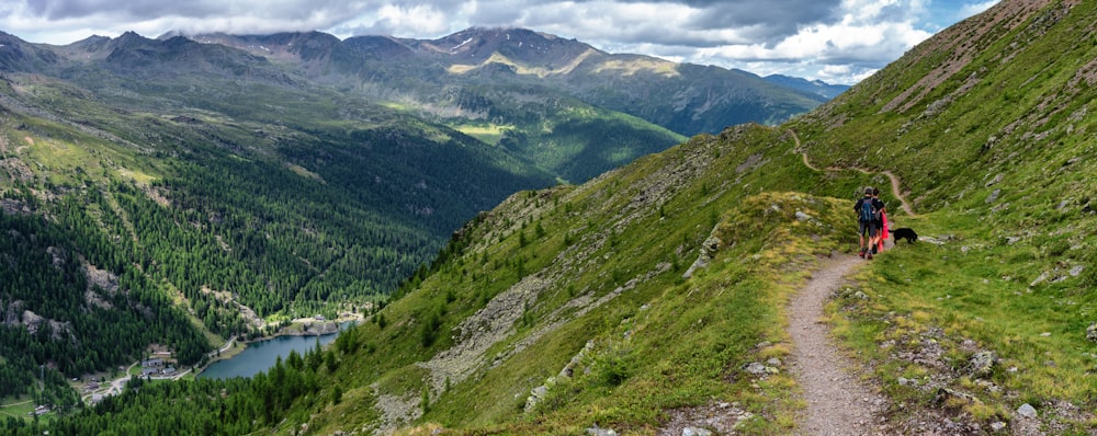 person walking on dirt road near mountain