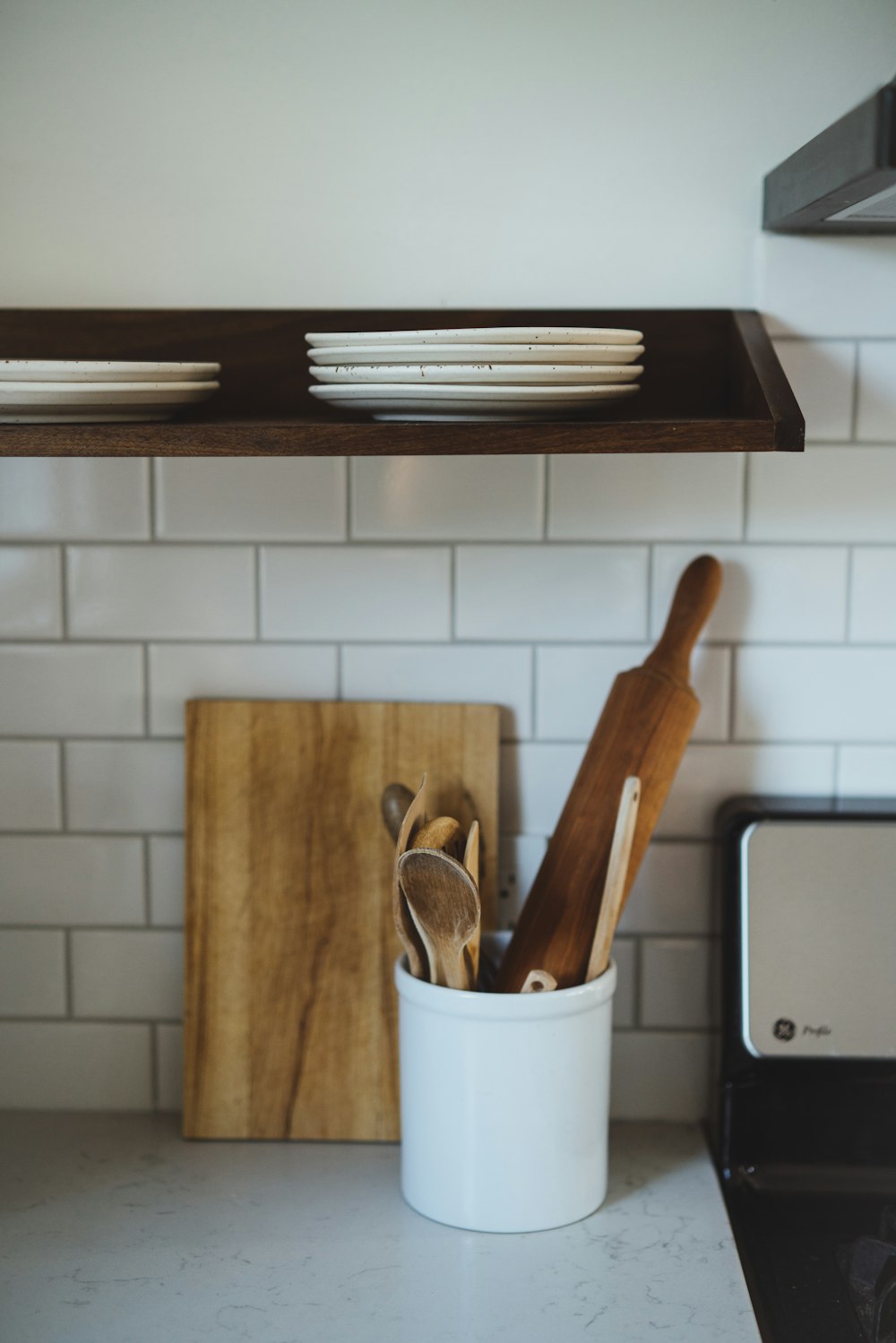 a kitchen counter with utensils and a cutting board