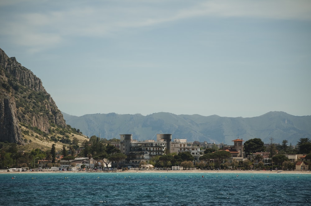 buildings on shore facing ocean under blue sky