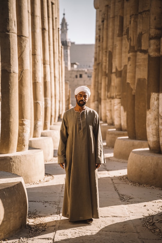 man stands between columns in Luxor Egypt