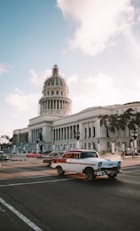 different vehicles on road viewing white dome historic building during daytime