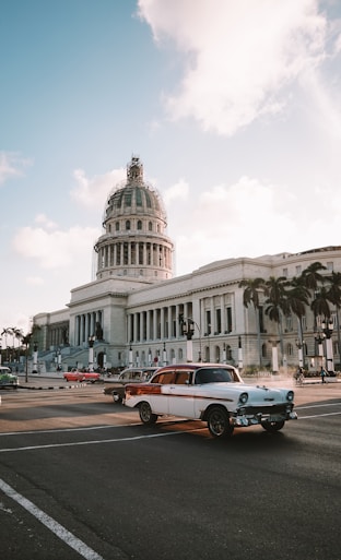 different vehicles on road viewing white dome historic building during daytime