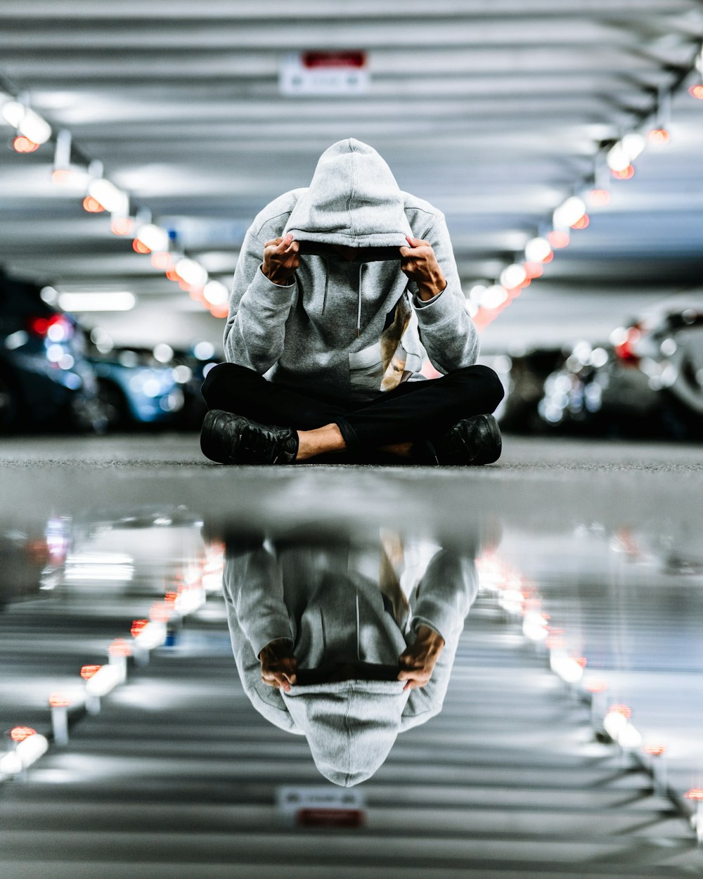 person sits while wearing hoodie