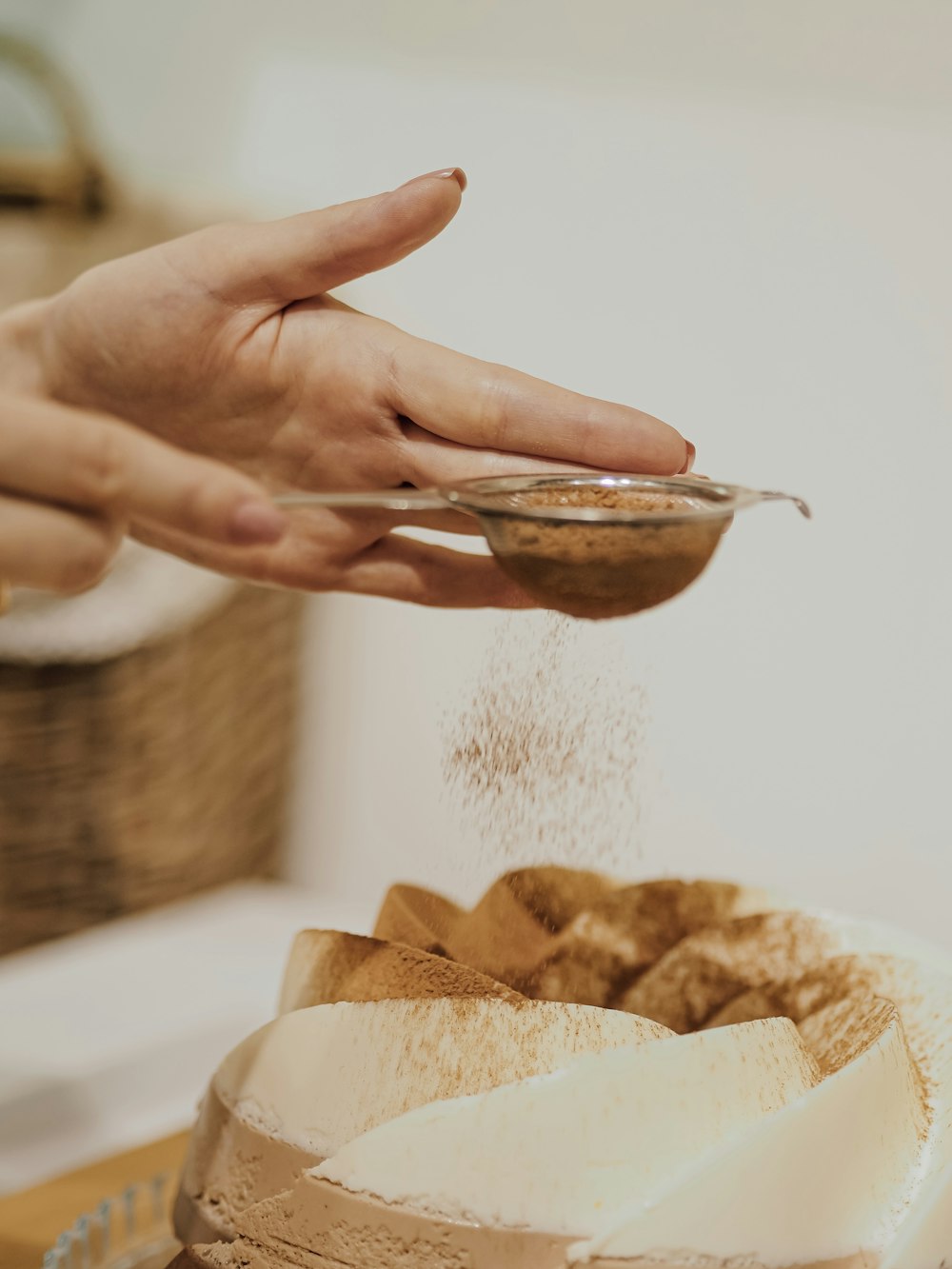 woman sprinkling dessert with cinnamon powder