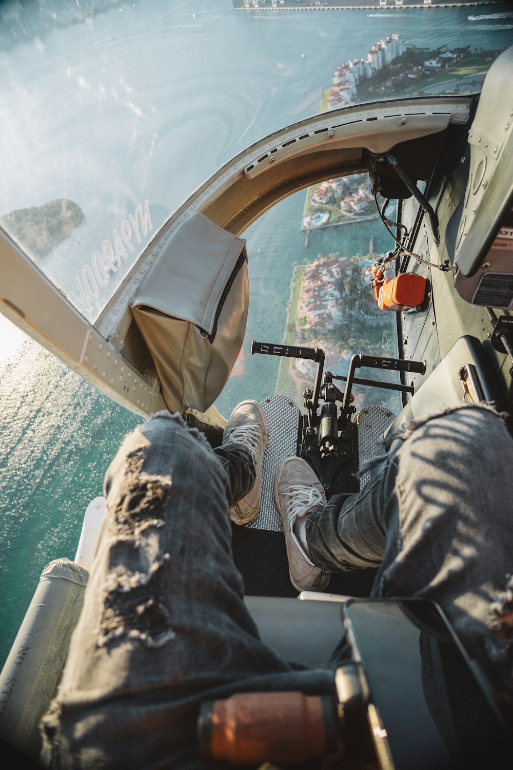 man riding helicopter above city during day