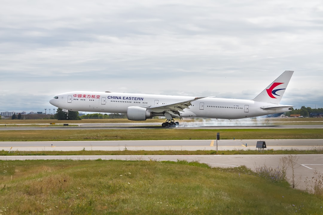 China Eastern airliner on airfield during day, Boeing Triple 7 Touching down