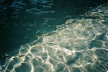 Crystal clear water reflecting sunlight in a tranquil setting.