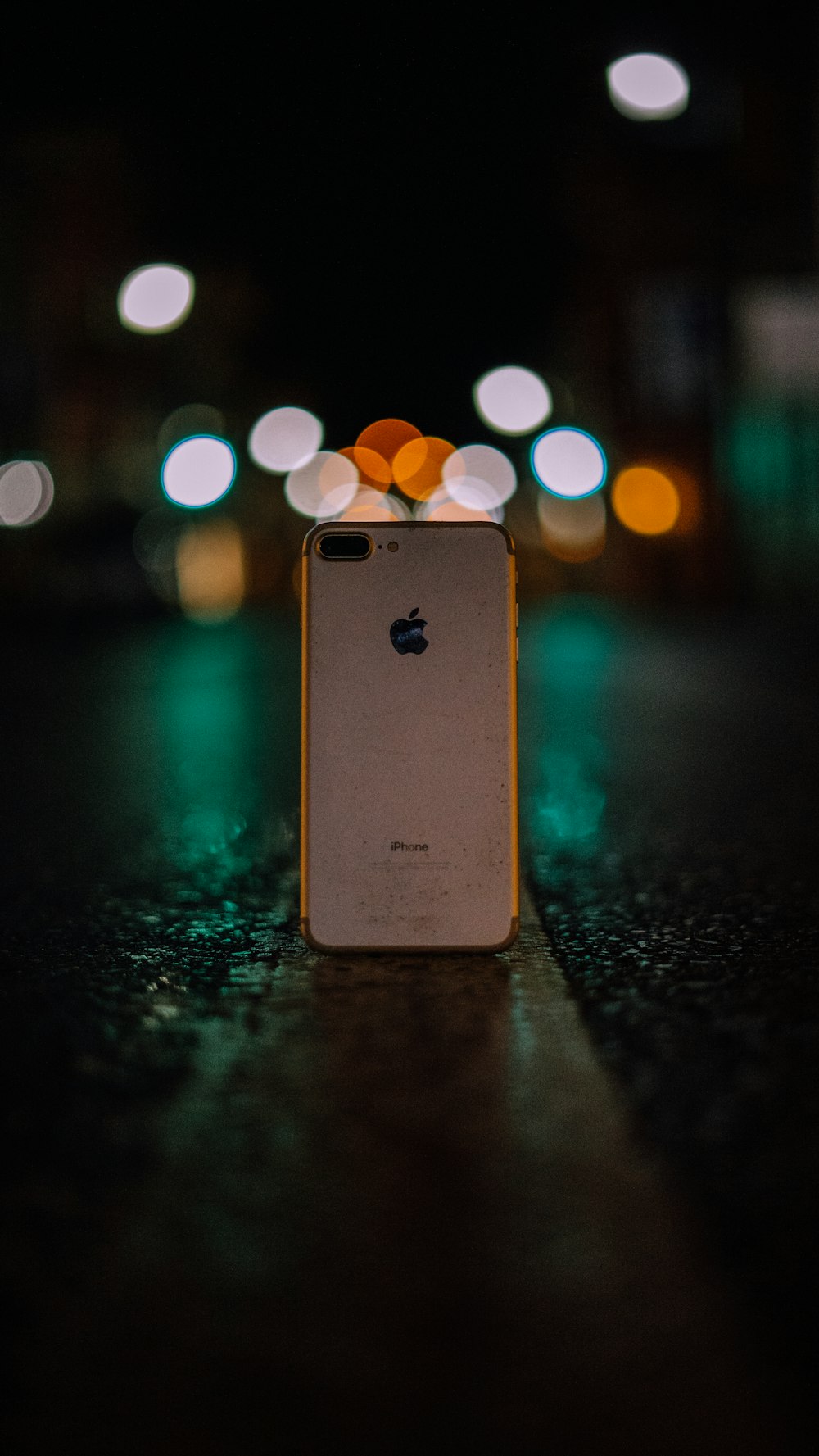 iPhone 8 Plus em ouro rosa em pé no meio da estrada durante a noite