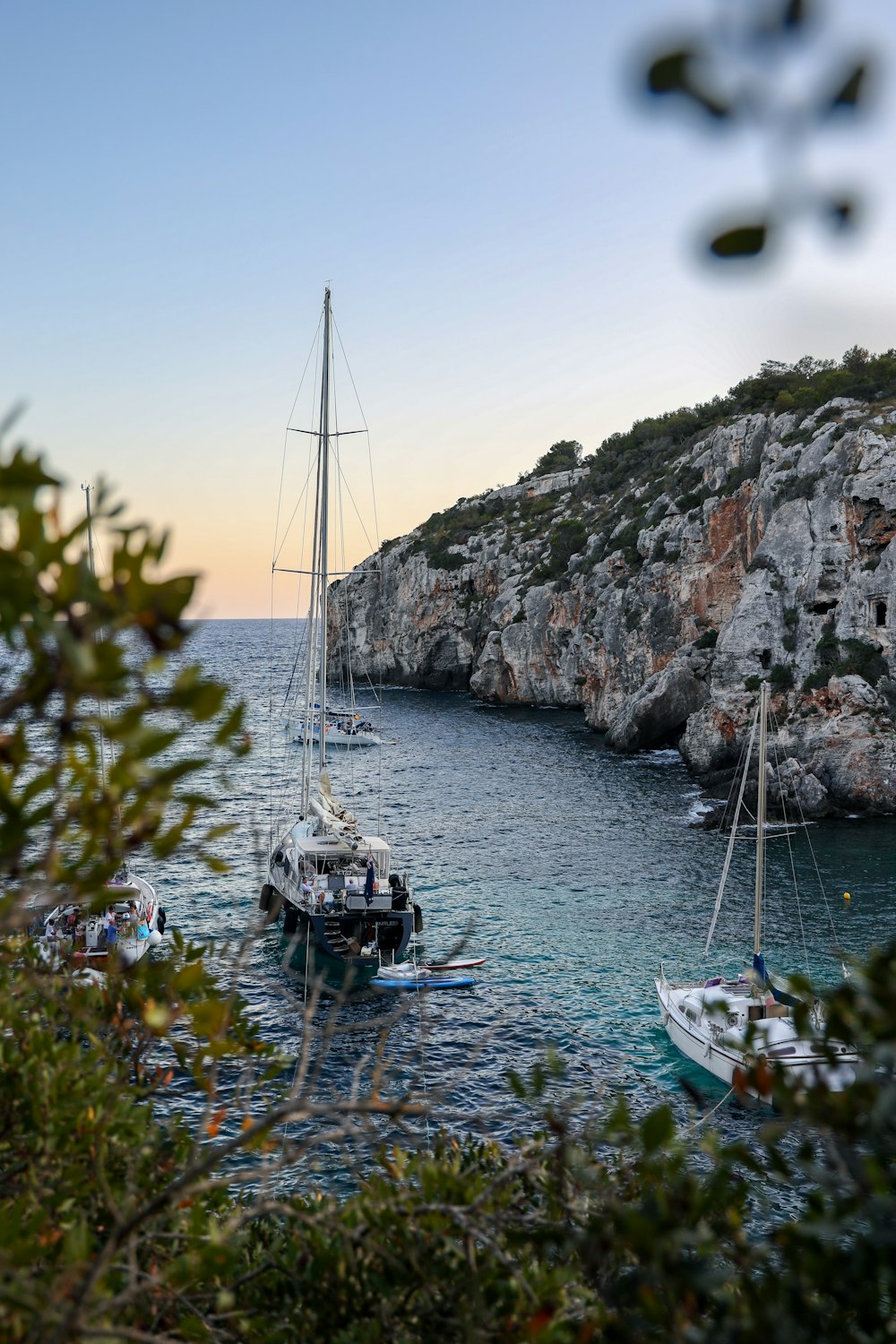 Bateaux à moteur blancs sur plan d’eau près de la montagne