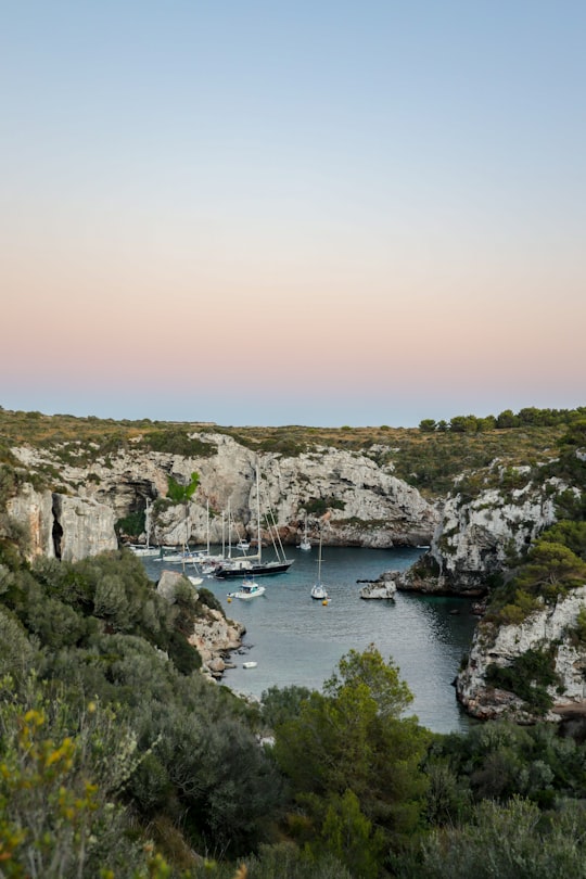 boats floating on body of water near mountains in Menorca Spain
