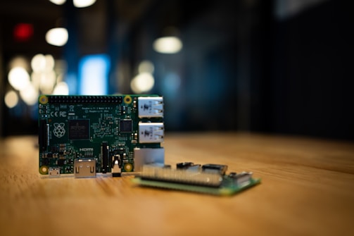 two green circuit boards on wooden surface