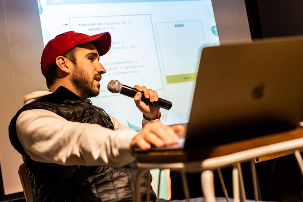 man using microphone front of MacBook