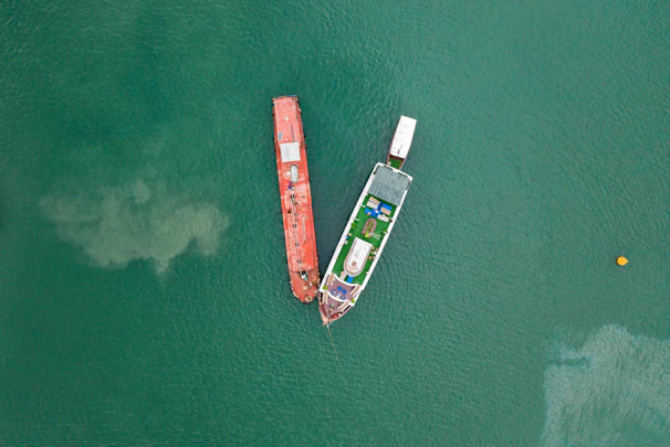 aerial photography of two boats on green sea during daytime
