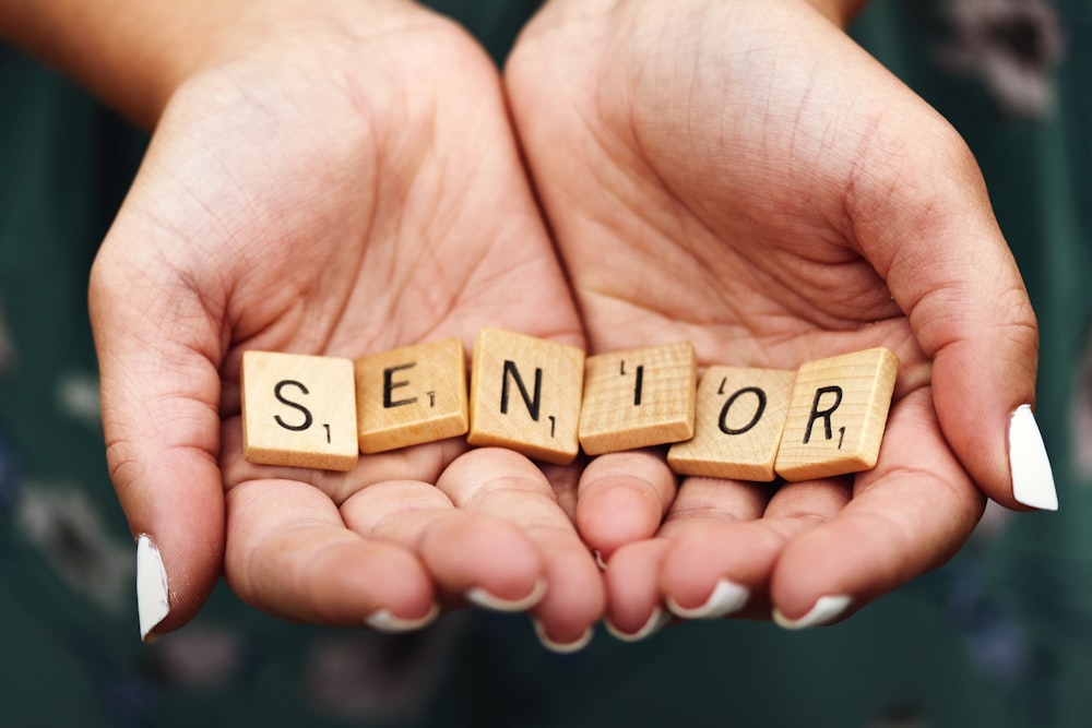 Senior dice on person's palm