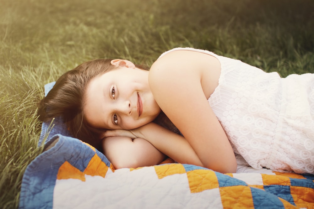 fille s’allonge sur le textile sur l’herbe