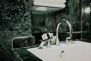 A sleek stackable bathroom organizer neatly holding toiletries beside a modern sink